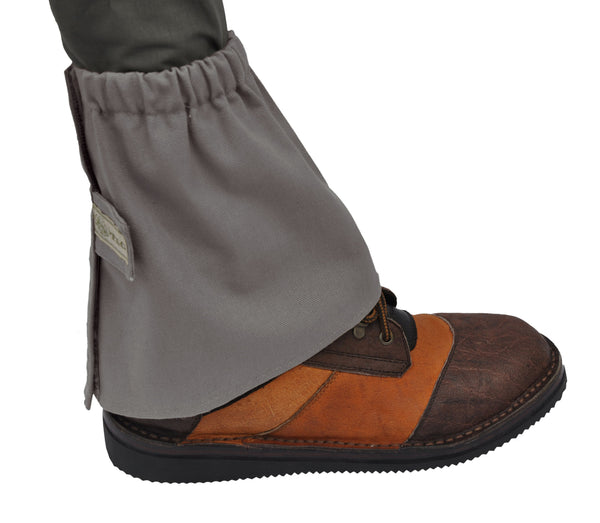 Side view of a Canvas Gaiter, color Olive. The gaiter has an elastic band at the top, a Velcro secured tab strap with a Tag Buffalo label in the middle, and a full Velcro fastener strip that runs vertically from top to bottom. 100% medium weight cotton canvas.