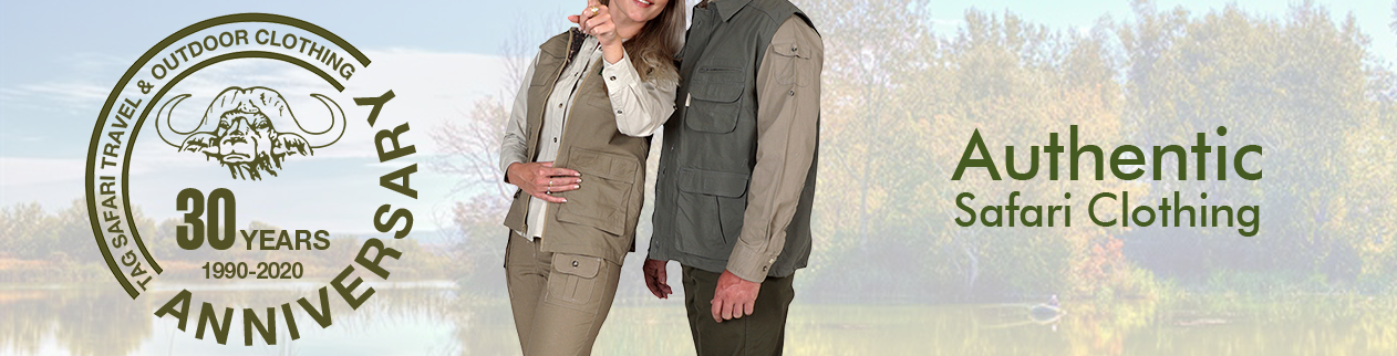 Man and Woman standing side by side wearing authentic safari style clothing pants shirt and vest while pointing at game and celebrating 30 years of Tag safari clothing