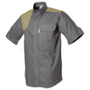 Front of a Men's Upland Shirt in Short Sleeves, color Olive/Khaki. The shirt has a contrasted quilted shooter patch, two flap-covered chest pockets, button-down collars, buttoned roll-up tabs on the sleeve cuffs, a button-front placket, double stitching throughout, and long rounded tails for tucking into pants. 100% cotton.