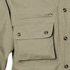Closeup of a Men's Left-Hand Shooter Shirt in Long Sleeves, color Khaki. The shirt has a zippered chest pocket, a flap-covered chest pocket below, a button-front placket, and double stitching throughout. 100% cotton.