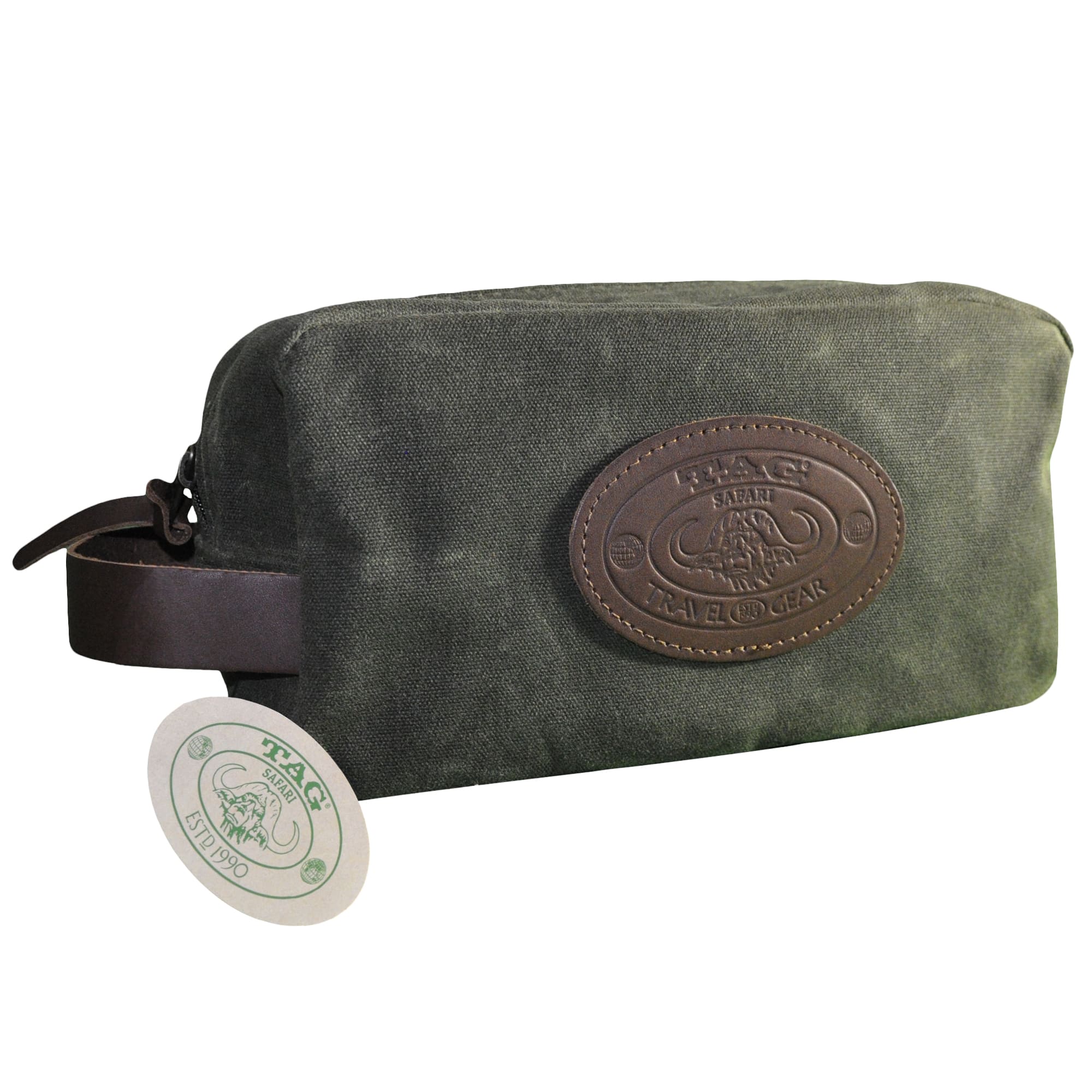 Front of a Tag Safari Waxed Cotton Canvas Toiletry Bag in Field Tan. Shows a zippered top, a leather hand strap on the left side, a leather side loop on the right side, and an embossed Tag logo leather patch.--5