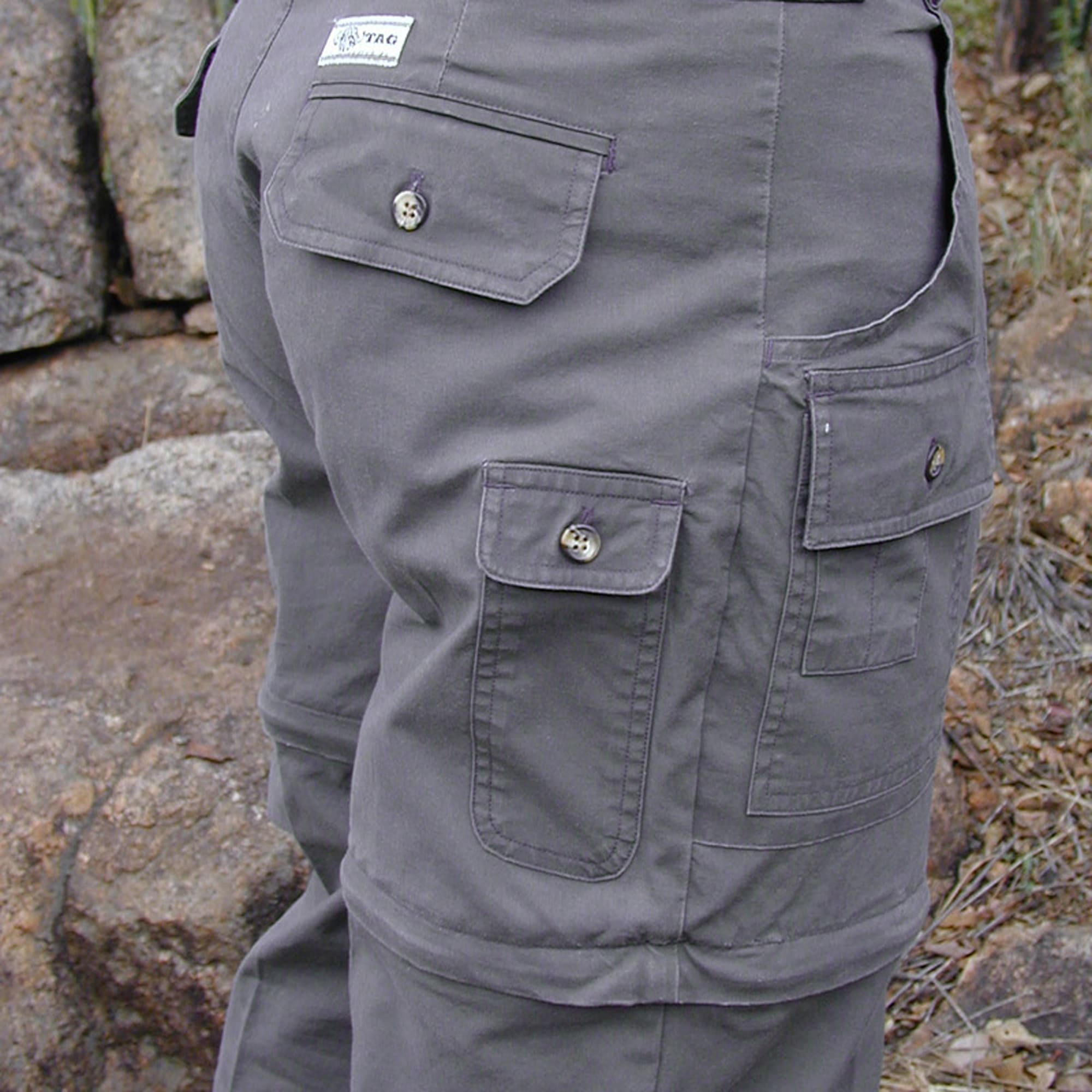 Tag Safari Zambezi Convertible Pants for Men feature zip-off legs, slash-style hip pockets, button-flap side, back, and utility pockets, discreet elastic waist panels, and large belt loops. Shown in Olive Gray.--3
