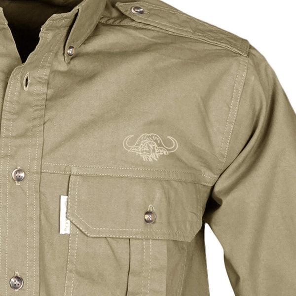 Closeup of a Men's Trail Shirt with Buffalo Logo in Long Sleeves, color Khaki. The shirt has a flap-covered chest pocket on the left side with an embroidered Tag buffalo logo above, button-down collars, functional cross-stitched shoulder straps, a button-front placket, and double stitching throughout. 100% cotton.