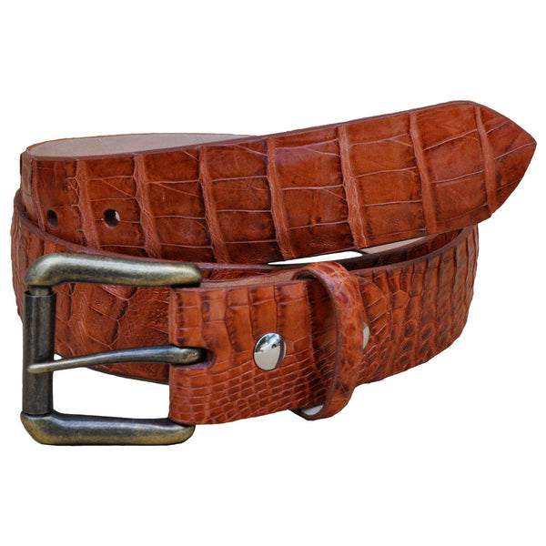 Front view of a Caiman Crocodile Game Skin Belt, color Cognac. The belt has a solid brass buckle, five waist adjustment positioning holes, two Chicago-style belt length adjustment screws, a matching leather keeper loop, and a Tag Safari logo branded inside. Genuine game skin leather.