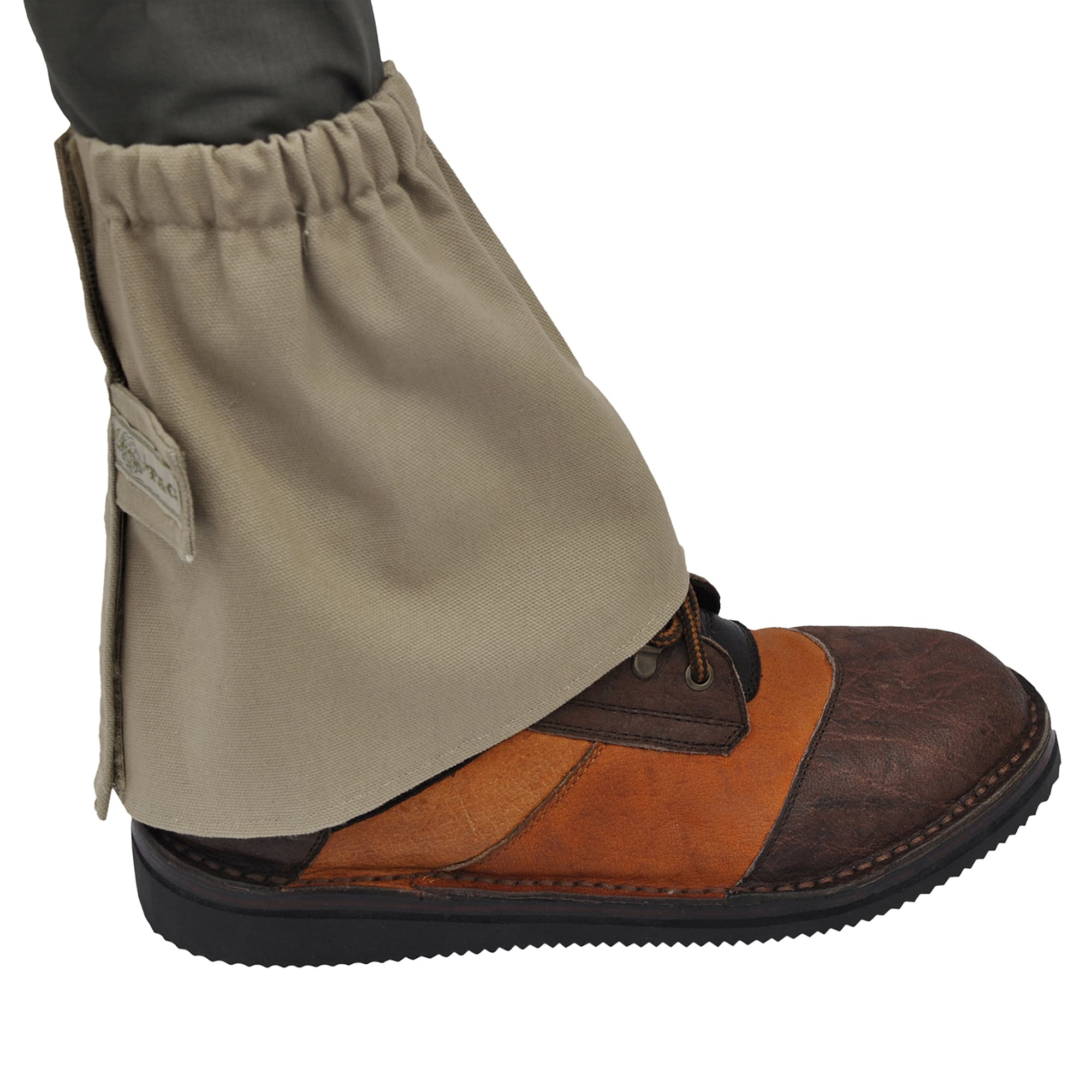 Side view of a Tag Safari Canvas Ankle Gaiter in Khaki. Shows an elasticized top, a full-height Velcro closure, and a fabric Velcro strap with a Tag nameplate.--1