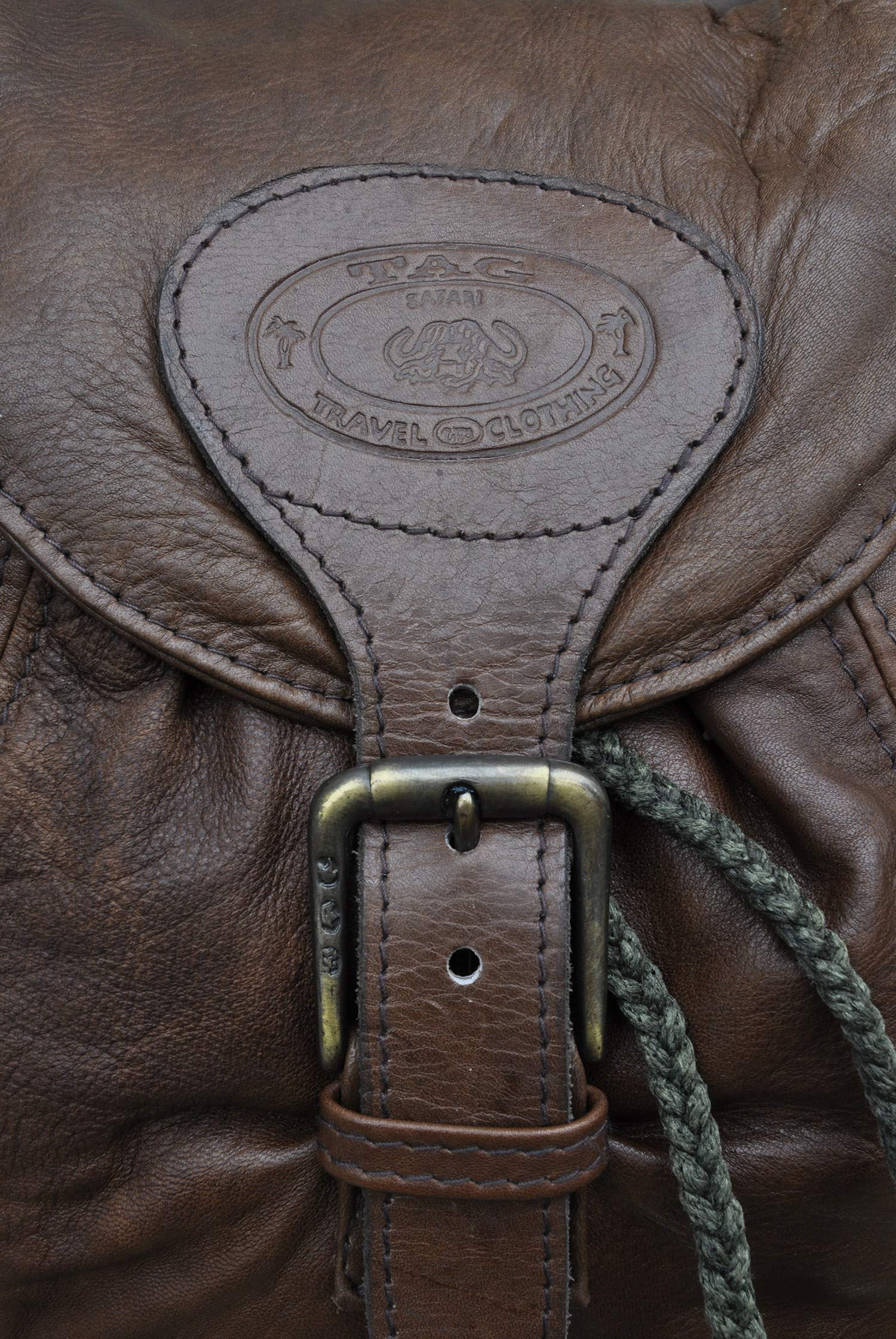 Impala Leather Backpack from Tag Safari in Brown features a buckled-flap top with embossed Tag logo, a cushioned handle, front and side flap-covered pockets, and adjustable padded shoulder straps with small flap-covered pouches.--4