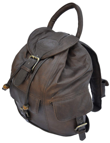 Front and right side of a Tag Safari Impala Leather Backpack in Brown. Shows a top flap with buckle and embossed Tag logo, top-closure draw cords, a cushioned handle, front and right side flap-covered pockets with buckles, and adjustable padded shoulder straps with flap-covered utility pouches.